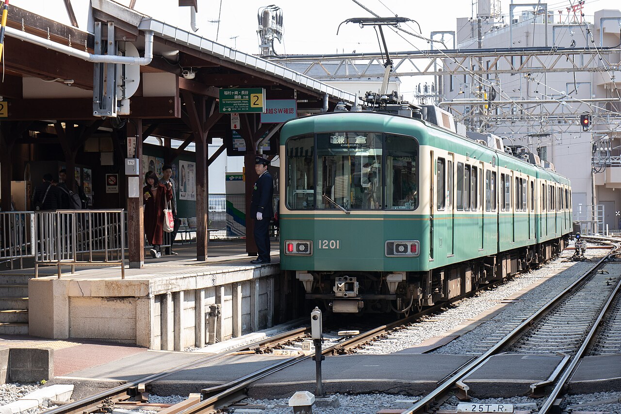 A green and cream Enoden 1000 series train at Enoshima Station