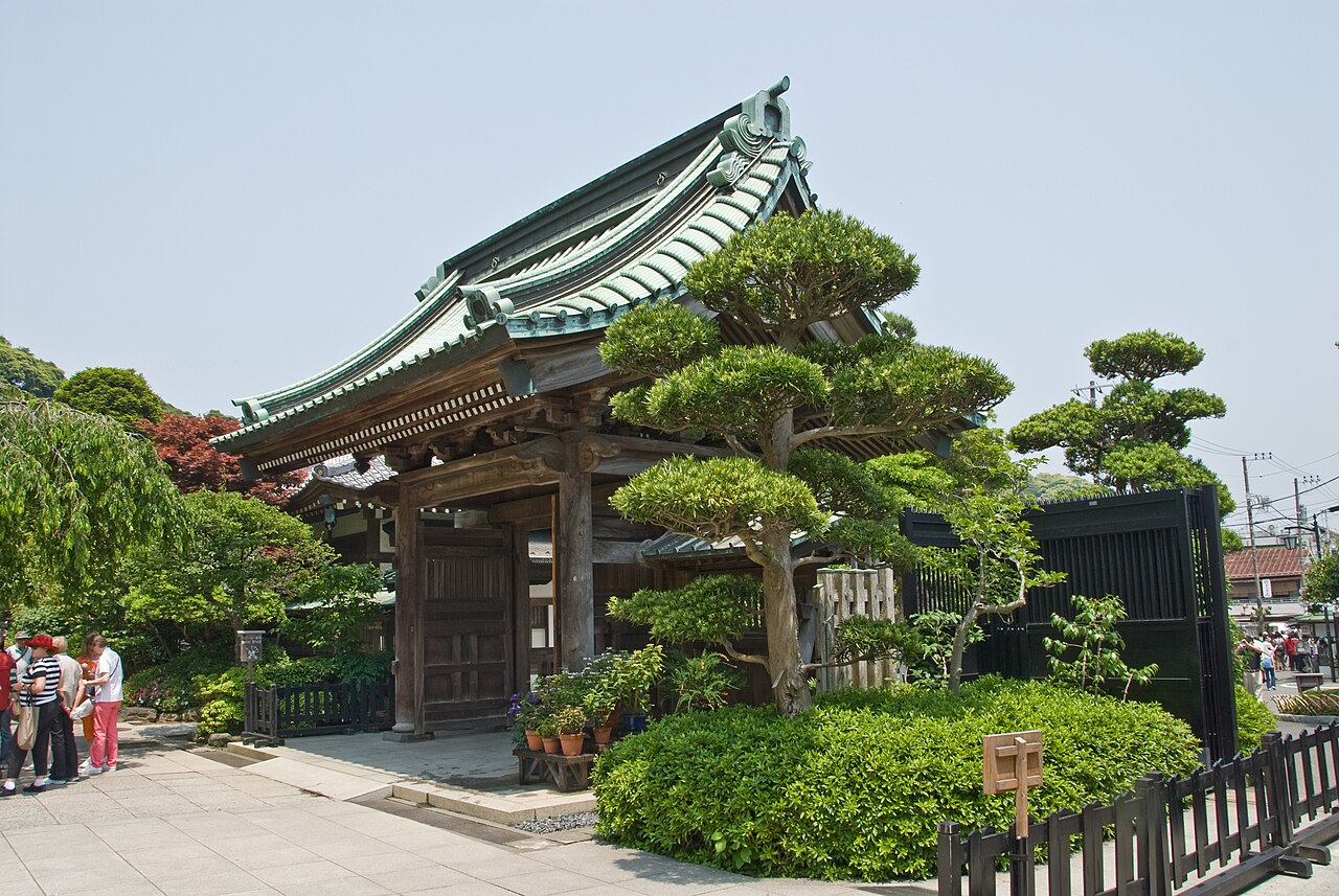 緑色の瓦屋根と木の柱、周囲の植栽が見える鎌倉・長谷寺の山門